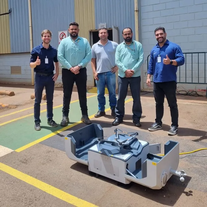 Equipe corporativa ao lado de drone em estrutura de operação industrial